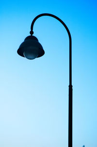 Low angle view of antique street light against clear blue sky