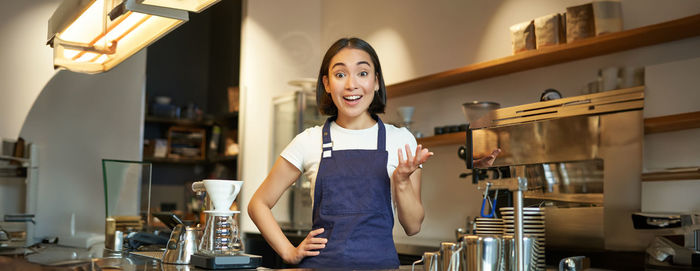 Portrait of young woman standing at home