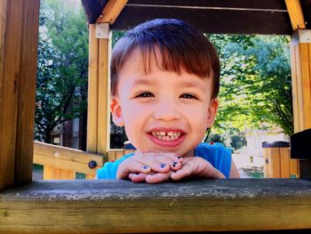 Portrait of cute smiling girl by wooden railing