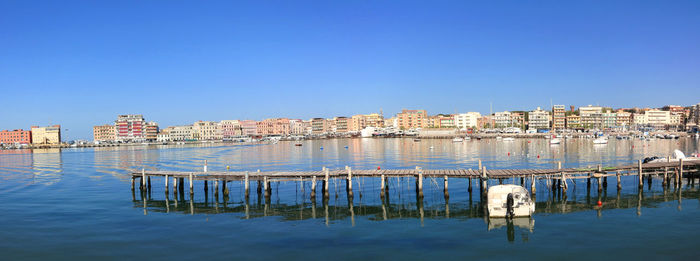 Reflection of buildings in river against blue sky