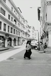 Woman walking on road in city