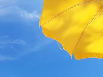 Low angle view of yellow flag against sky