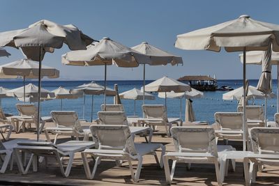 Chairs and parasols on beach against sky