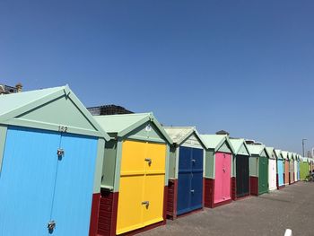 Multi colored umbrellas on beach against clear blue sky