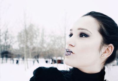 Woman wearing glitter lipstick against sky