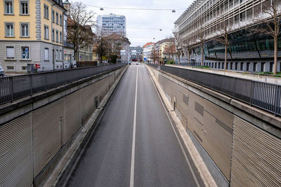 Road amidst buildings in city against sky