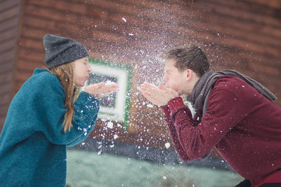 Close-up of friends blowing snow