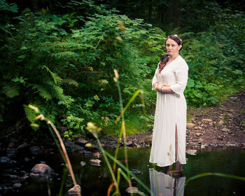 Portrait of mature woman standing in pond