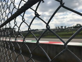 Close-up of chainlink fence against sky