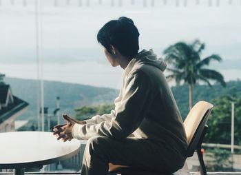 Side view of senior man sitting on railing