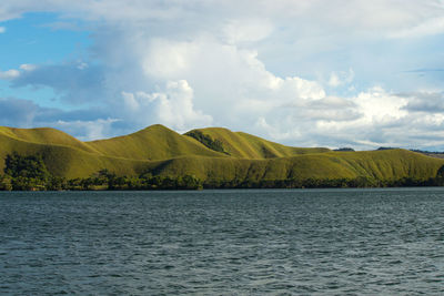 Scenic view of lake by mountains against sky