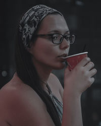 Portrait of young woman drinking drink