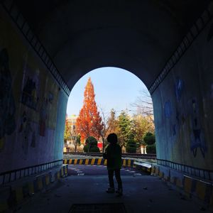 Rear view of man standing in tunnel