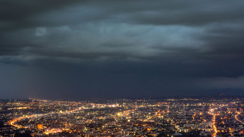 Aerial view of illuminated city against sky at night