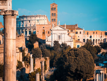 Buildings in city against sky, coloseum and rome