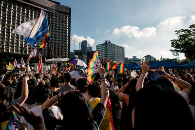 Group of people on street against buildings in city