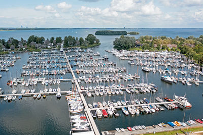 High angle view of sailboats moored in sea against sky