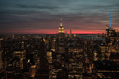 Illuminated buildings in city against sky