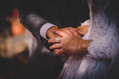 Midsection of couple holding hands