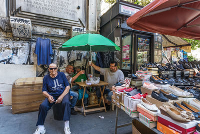 Portrait of people sitting at market stall