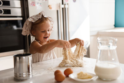 Little girl cooking pizza in the kitchen