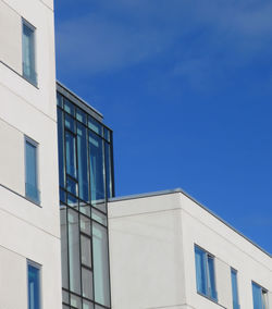 Low angle view of modern building against clear blue sky