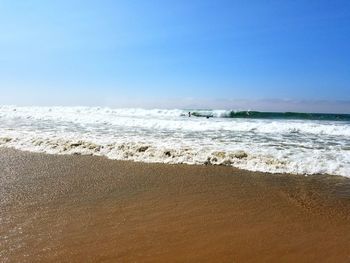 Scenic view of beach against blue sky