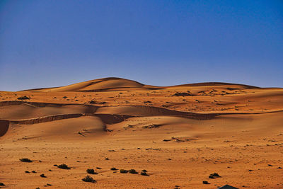 Scenic view of desert against clear blue sky