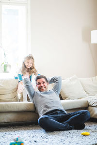 Portrait of smiling woman sitting on sofa at home