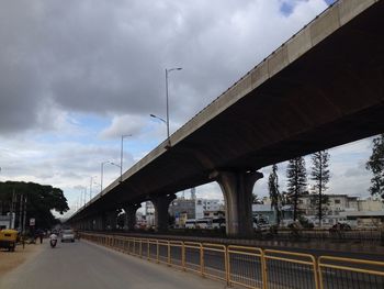 Bridge over highway in city against sky