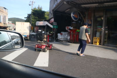 Rear view of man walking on road in city