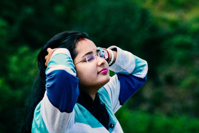 Portrait of young woman photographing through camera