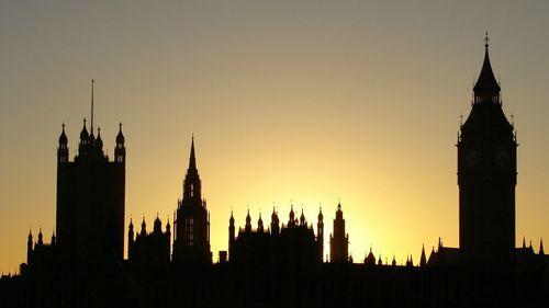 Silhouette big ben in city against sky during sunset