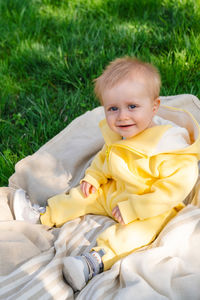 Portrait of cute baby boy lying on grass