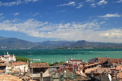 High angle view of city by sea against sky