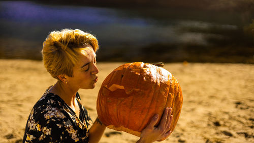 Rear view of young woman sitting on field