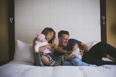 Happy family enjoying on bed at home