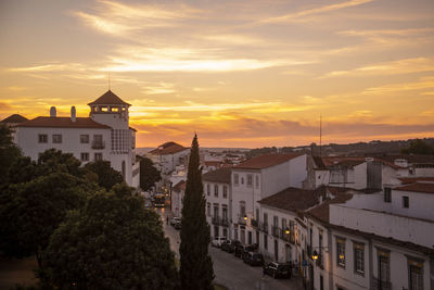 Buildings in city against sky during sunset