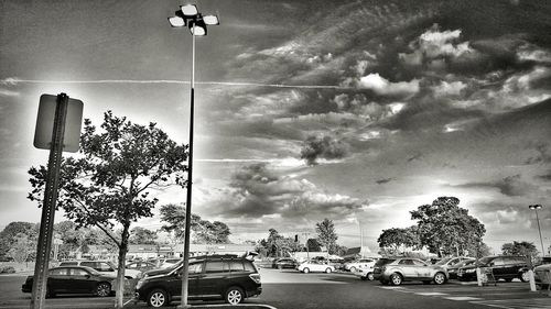 Cars on road against cloudy sky
