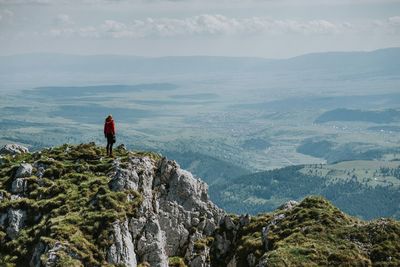 Woman standing on cliff against sky