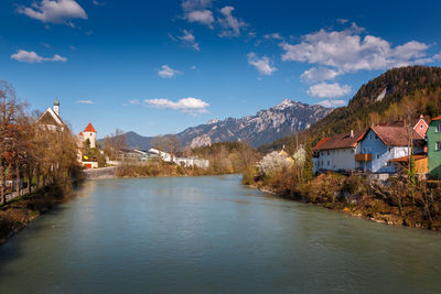 River amidst buildings and mountains against sky