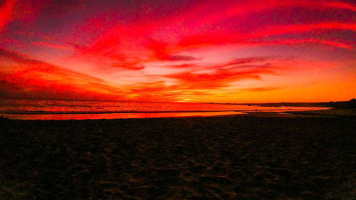 Scenic view of beach against orange sky