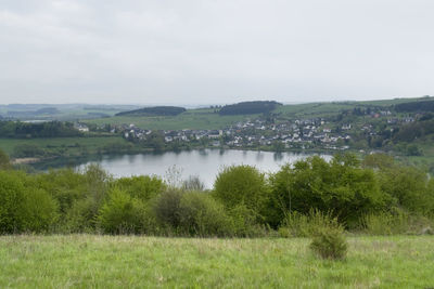 Scenic view of river by landscape against sky