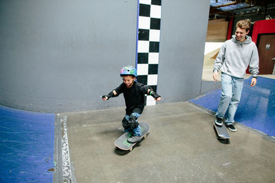 Skateboard instructor smiles at student as he rides his skateboard