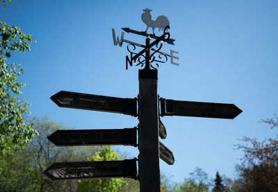 Low angle view of weather vane against sky