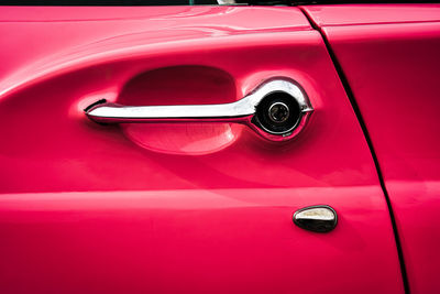 Chrome door handle of vintage pink t-bird or thunderbird american automobile