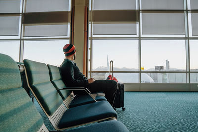 Rear view of man sitting on seat in airport