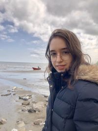 Portrait of smiling girl on beach against sky