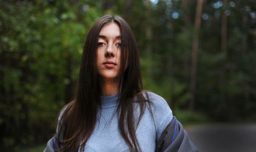 Portrait of young woman standing in forest