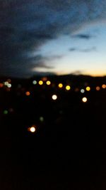 Close-up of illuminated lights against sky at night